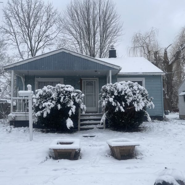 Snow covered beautiful house with bushes at the front