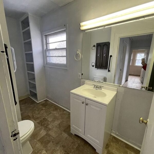 a sink, commode and mirror in the bathroom