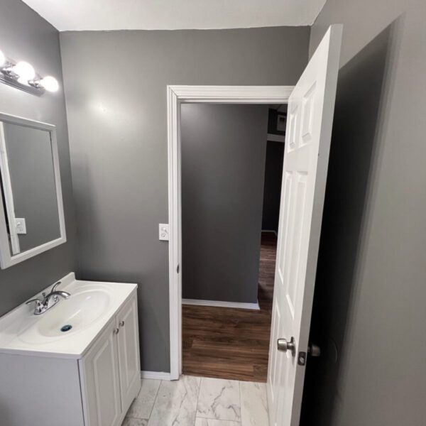 sink, mirror, and an open bathroom door