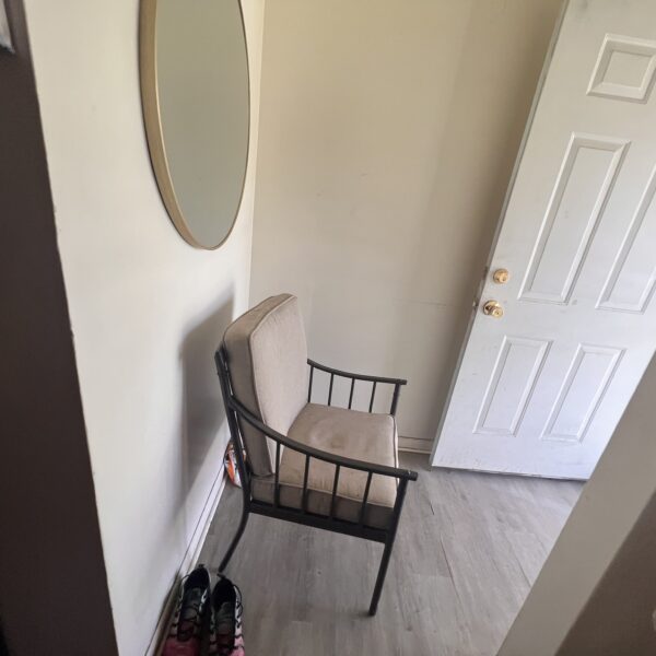 a chair near the door and mirror above it