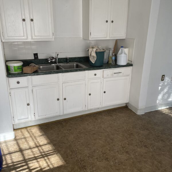 a small kitchen counter with white cabinets