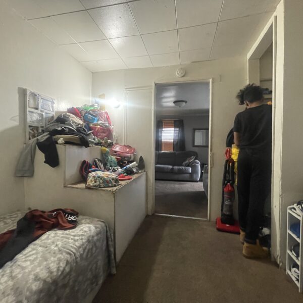 a person in black outfit in a bedroom