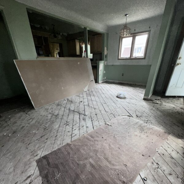 An empty living room with a wooden floor.