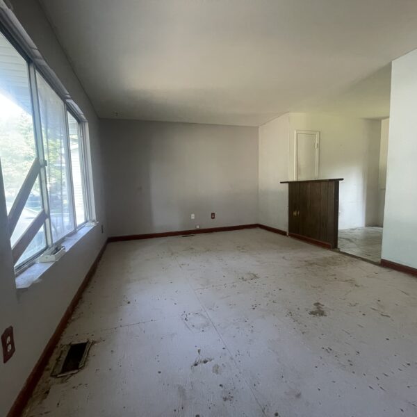 Empty living room with a white floor and a window.